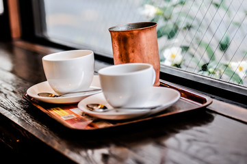 two empty cups of hot chocolate or coffee cappuccino on the table in cafe, close up