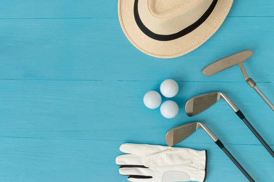 Golf concept : panama hat, glove, golf balls, golf clubs on wooden table. Flat lay with copy space.