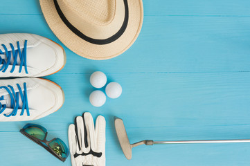 Golf concept : panama hat, glove, golf balls, golf clubs, golf shoes, sunglasses on wooden table. Flat lay with copy space.