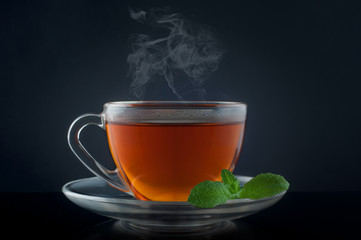 Cup tea with mint on a black background