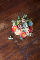 bridal bouquet with peonies and protea and boutonniere on the wooden floor