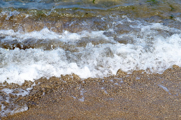 Small waves of the sea with  on a sandy beach