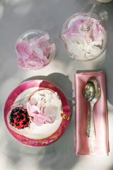 table setting in pink tones with berry cupcakes