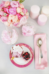 table setting in pink tones with berry cupcakes
