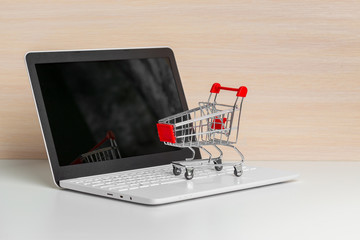 Shopping Cart On Laptop At Wooden Table