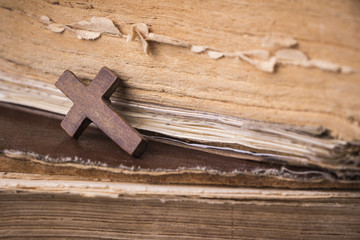 Brown cross on the Bible. Holy book.