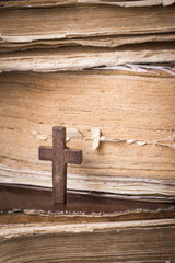 Brown cross on the Bible. Holy book.