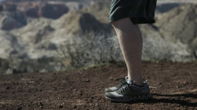 slow motion man doing burpees on desert mountaintop