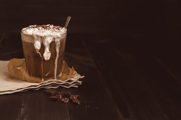 Ice coffee drink with chocolate on the wooden table, with copy space