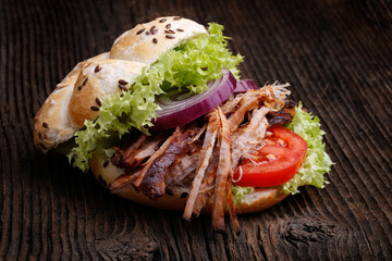Pulled pork burger with coleslaw tomato, onion and fresh bread.