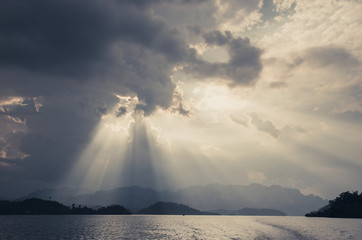 Beautiful sun rays through the clouds over mountains,evening light,Amazing scene at Khao-Sok...