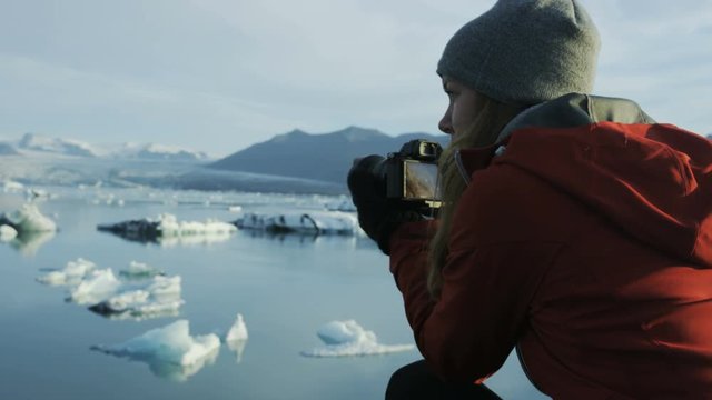 woman taking photos of icebergs in Iceland