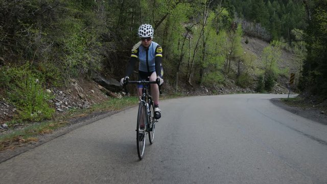 Woman road biking through mountains