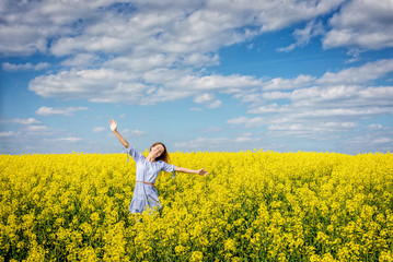 Fototapeta premium Carefree woman in rapeseed field