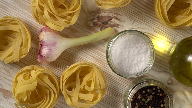 pasta, oil, tomatos and garlic on wooden background