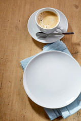 Cup of coffee and empty white plate