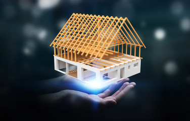 Businessman holding 3D rendering unfinished plan house in his hand