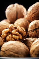 Walnuts. On a black background. Rustic. Fresh autumn walnut harvest in the village