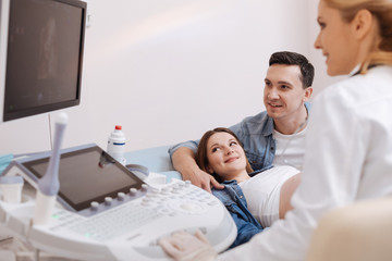 Obraz premium Optimistic couple enjoying appointment at the sonography cabinet