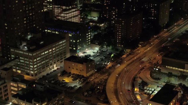 AERIAL HELI SHOT Flying above Brooklyn Bridge highway, Brooklyn Heights residential apartment buildings in Concord Village towards court houses revealing stunning cityscape lit up with lights at night