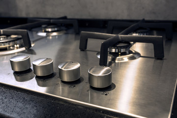 Fototapeta na wymiar new silver colored modern stainless gas stove - part of kitchen interior