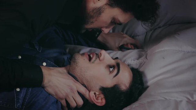 close up on Passionate and aggressive kisses between a homosexual couple