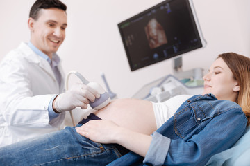 Obraz premium Charismatic doctor providing ultrasound pregnant patient checkup at work