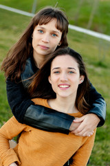 Naklejka premium Outdoor portrait of two happy sisters relaxed