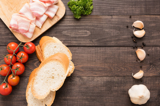 Ingredients for sandwich with smoked meat, baguette on wooden background