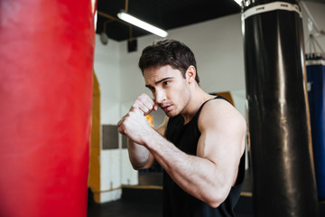 Side view of boxer  training with punchbag