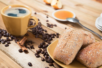 Crispy rolls with butter, apple jelly and hot coffee for breakfast