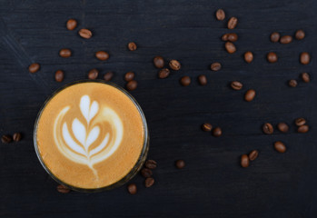 A cup of coffee cappuccino on a black wooden background