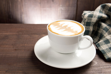 A cup of coffee on wooden background