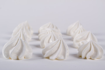 Closeup of mini meringues cookies on white background