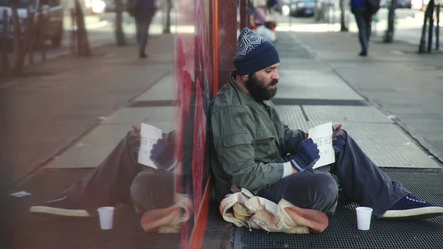 profile of hungry homeless asking charity in the street