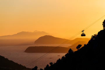 Cableway or ropeway to the mountain Srdj in Dubrovnik, Croatia against the background of a sunset over the islands in the sea