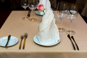 Pink rose in a vase as table decoration. Table setting