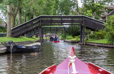 Fototapeta premium Tourists in small boats under the bridges of Giethoorn
