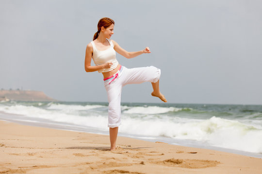 photo of beautiful young woman doing joga on the wonderful see and sky background