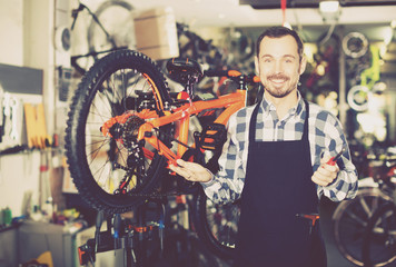 Obraz na płótnie Canvas Man working on master mechanic assembling bicycle equipment