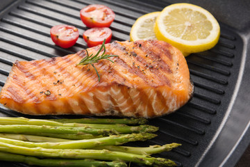 Grilled salmon cooked BBQ on a pan on wooden background
