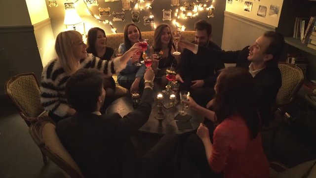 Happy friends around the table make a toast