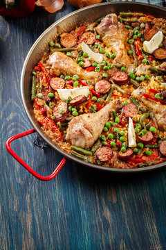 Traditional paella with chicken legs, sausage chorizo and vegeta