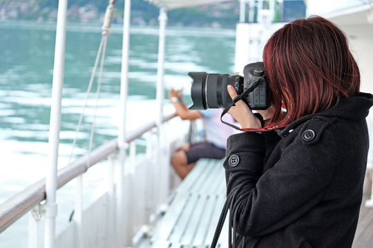 tourist woman with photo shooting lake Thun, Switzerland