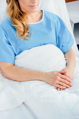 partial view of woman resting in hospital bed