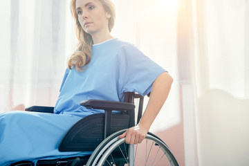 side view of pensive wheelchair woman in hospital chamber