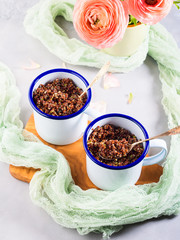 Red quinoa with vegetables in enamel mugs. Vegetarian gluten free lunch