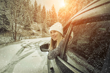 Woman at winter time. Yoyng female looking in window of her blac