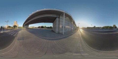 VALENCIA, SPAIN - JULY 15 2016: 360 VR video. City view with empty roads and bridge at sunset. Parents and child (with model release) walking on sidewalk and crossing the street on zebra