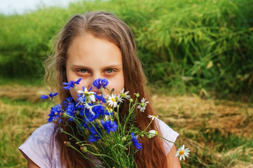 Girl child with a bouquet of wildflowers.